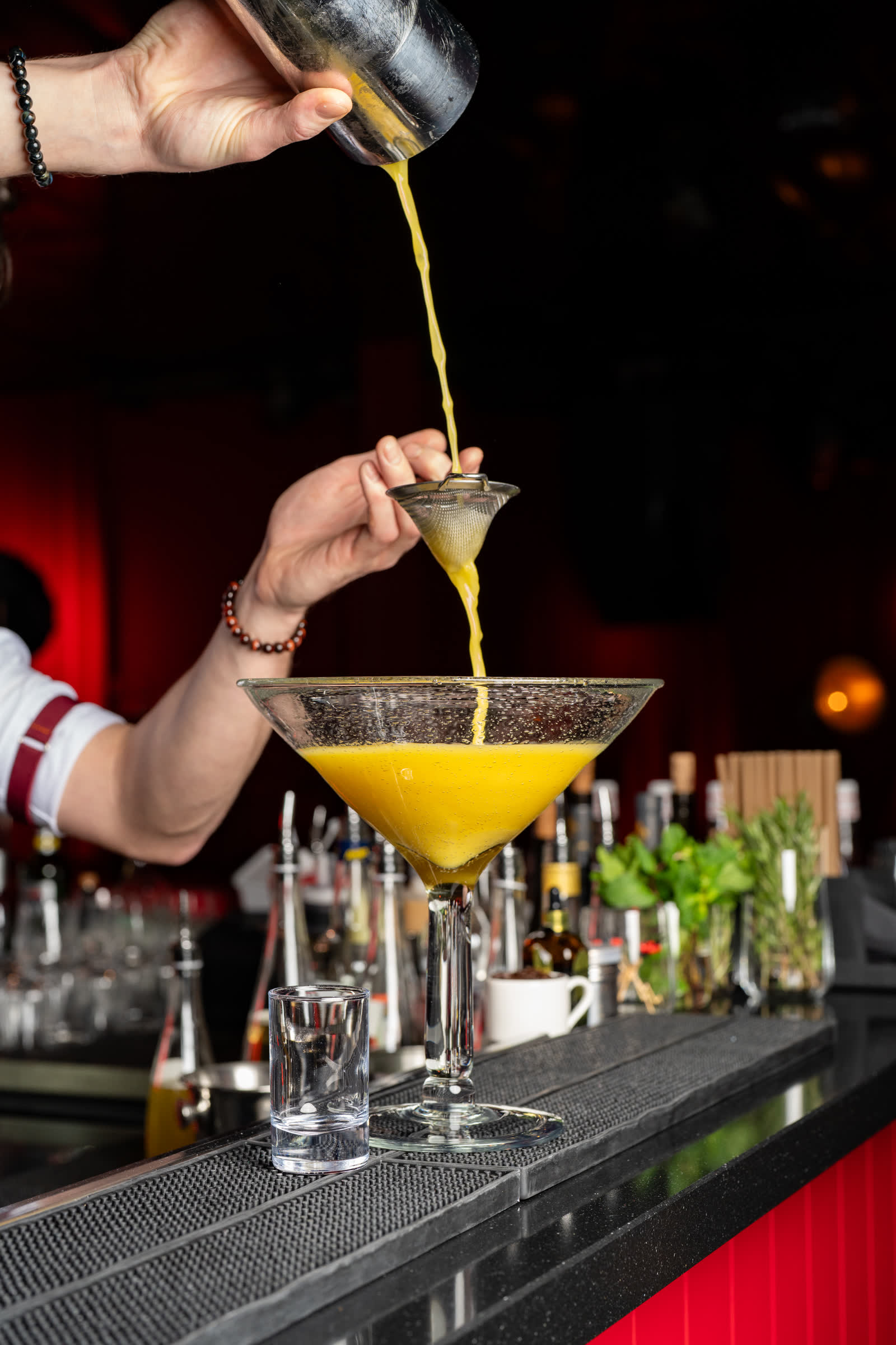 Un cocktail versé dans un verre, en contre-jour.