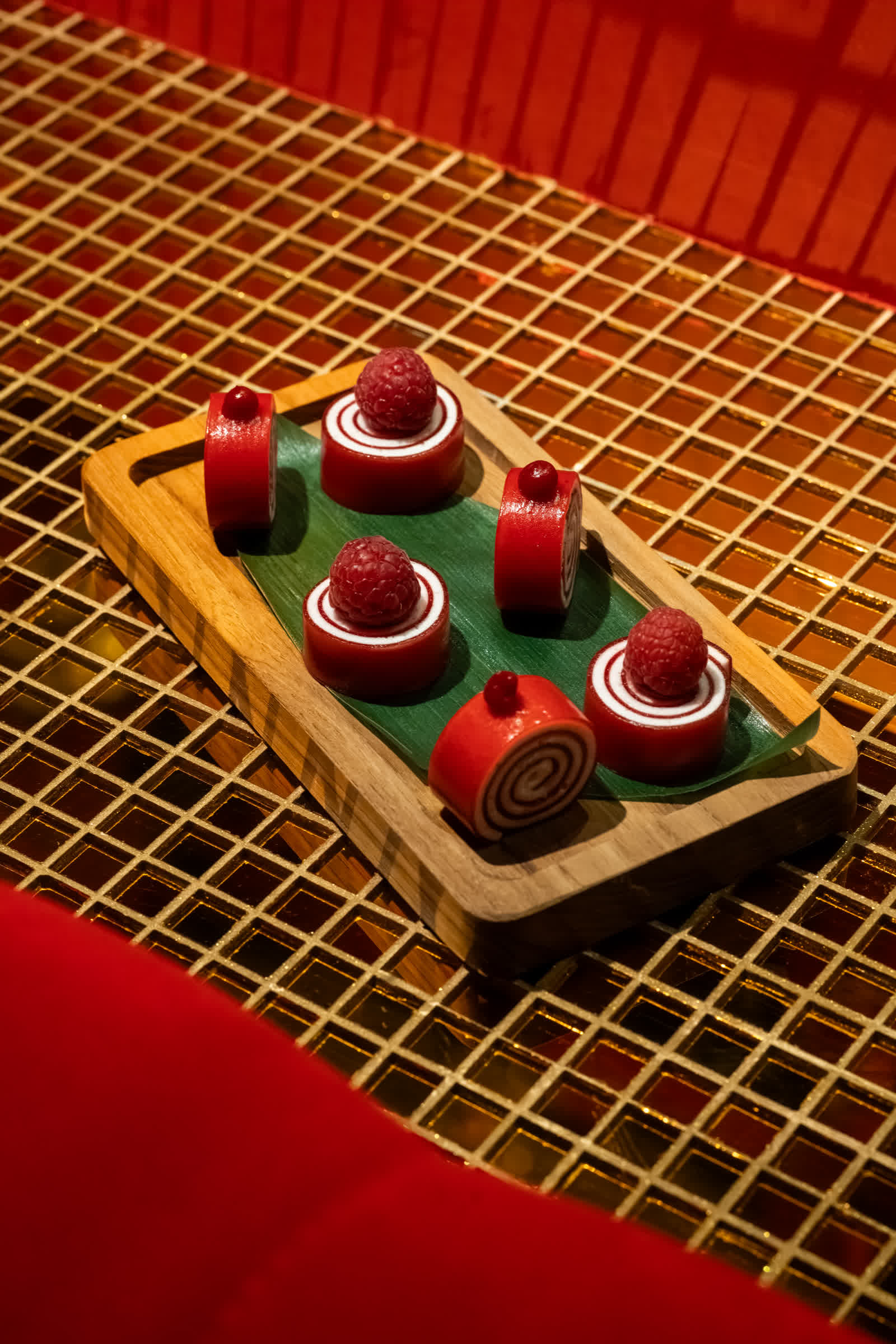 Trois desserts rouges sur une planche de bois.