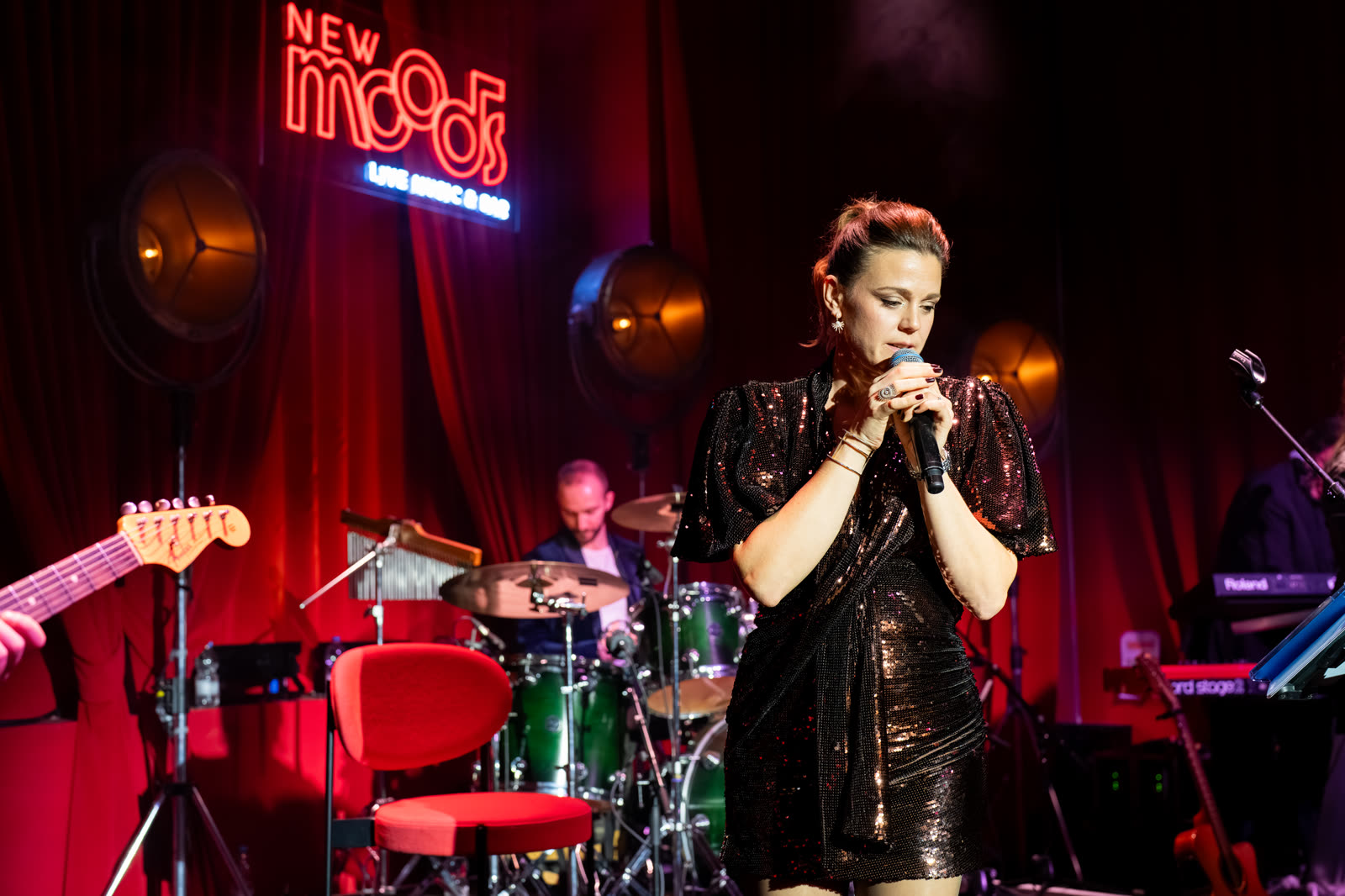 L'enseigne au néon derrière une chanteuse sur scène.