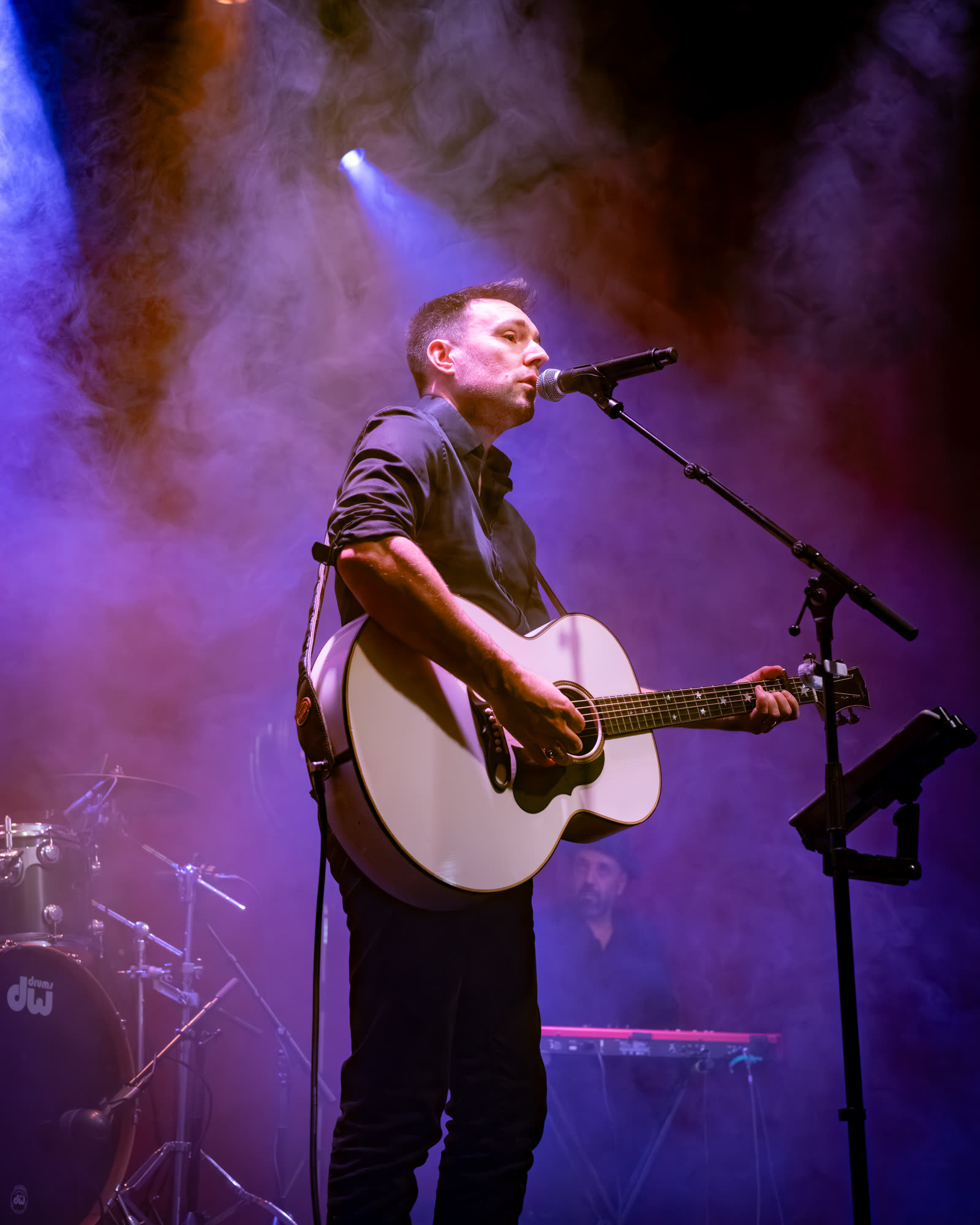 Un guitariste acoustique sur la scène.